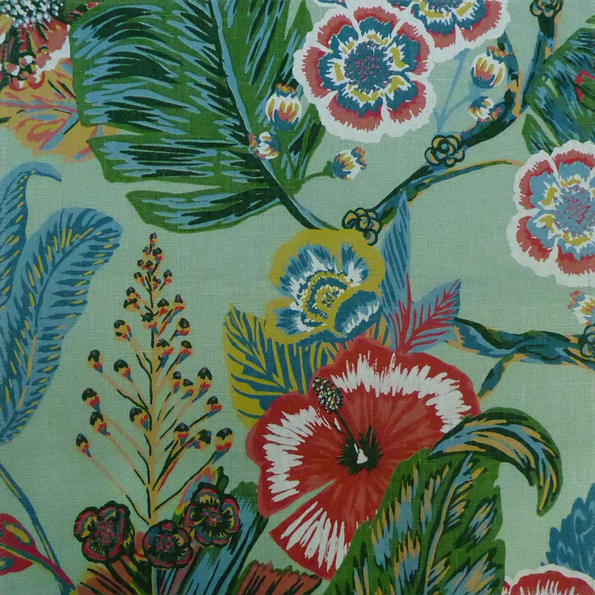 Detail of fabric in a large-scale botanical and bird print in shades of green, blue, red and yellow on a teal field.