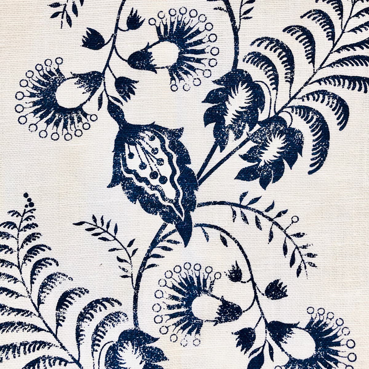 Detail of fabric in a floral trellis print in navy on a cream field.