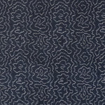 Detail of fabric in a minimalist wood grain print in white on an indigo field.