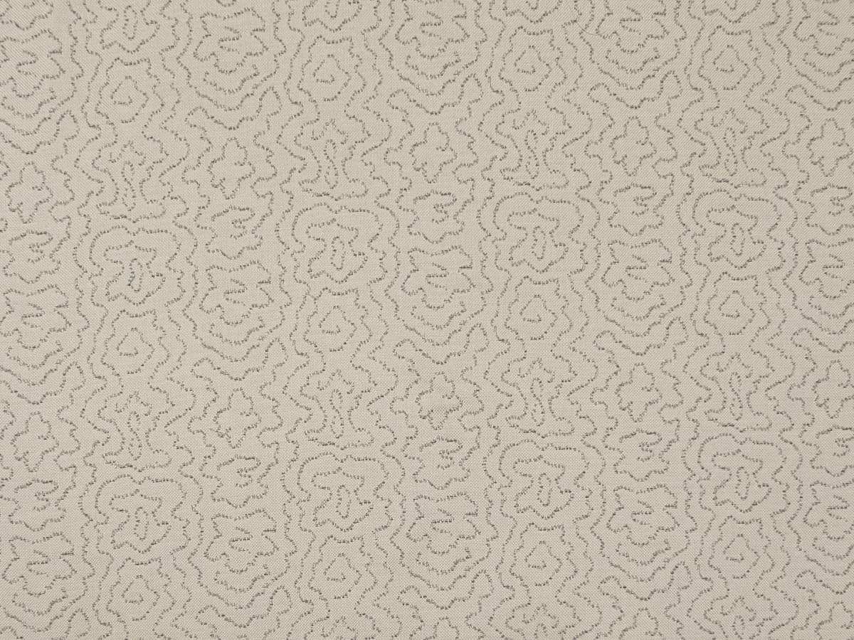 Detail of fabric in a minimalist wood grain print in gray on a cream field.