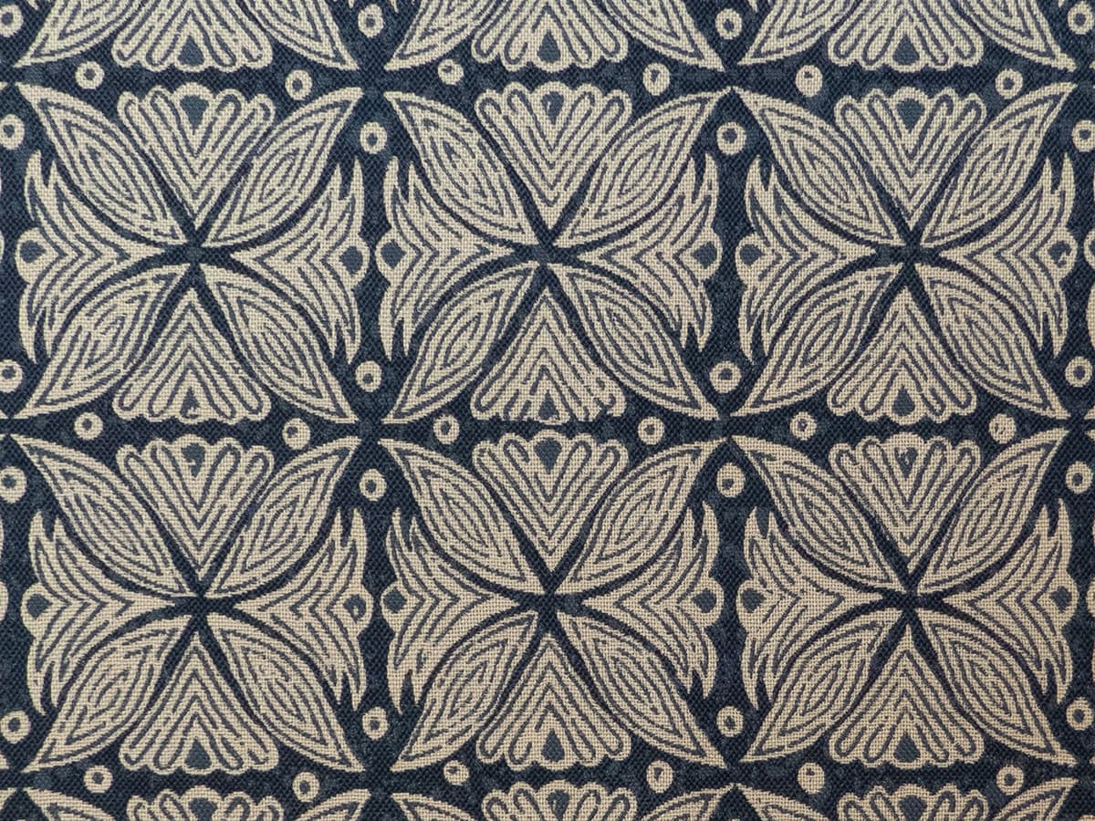 Detail of fabric in a botanical geometric print in shades of brown and navy.