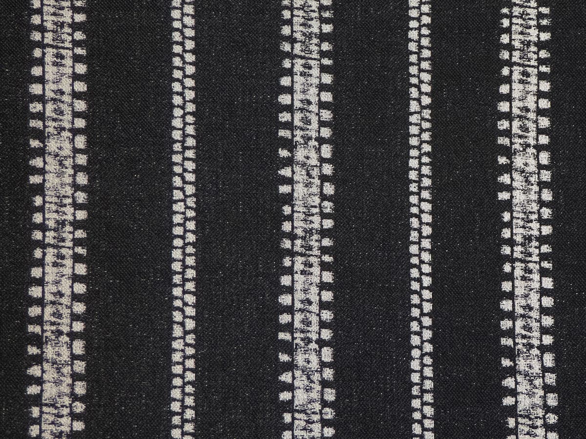 Detail of fabric in an irregular stripe print in white on a black field.