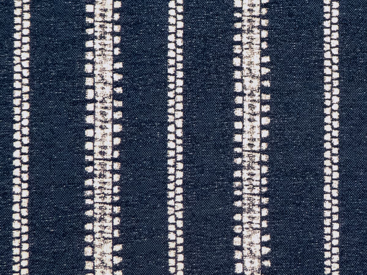 Detail of fabric in an irregular stripe print in white on an indigo field.