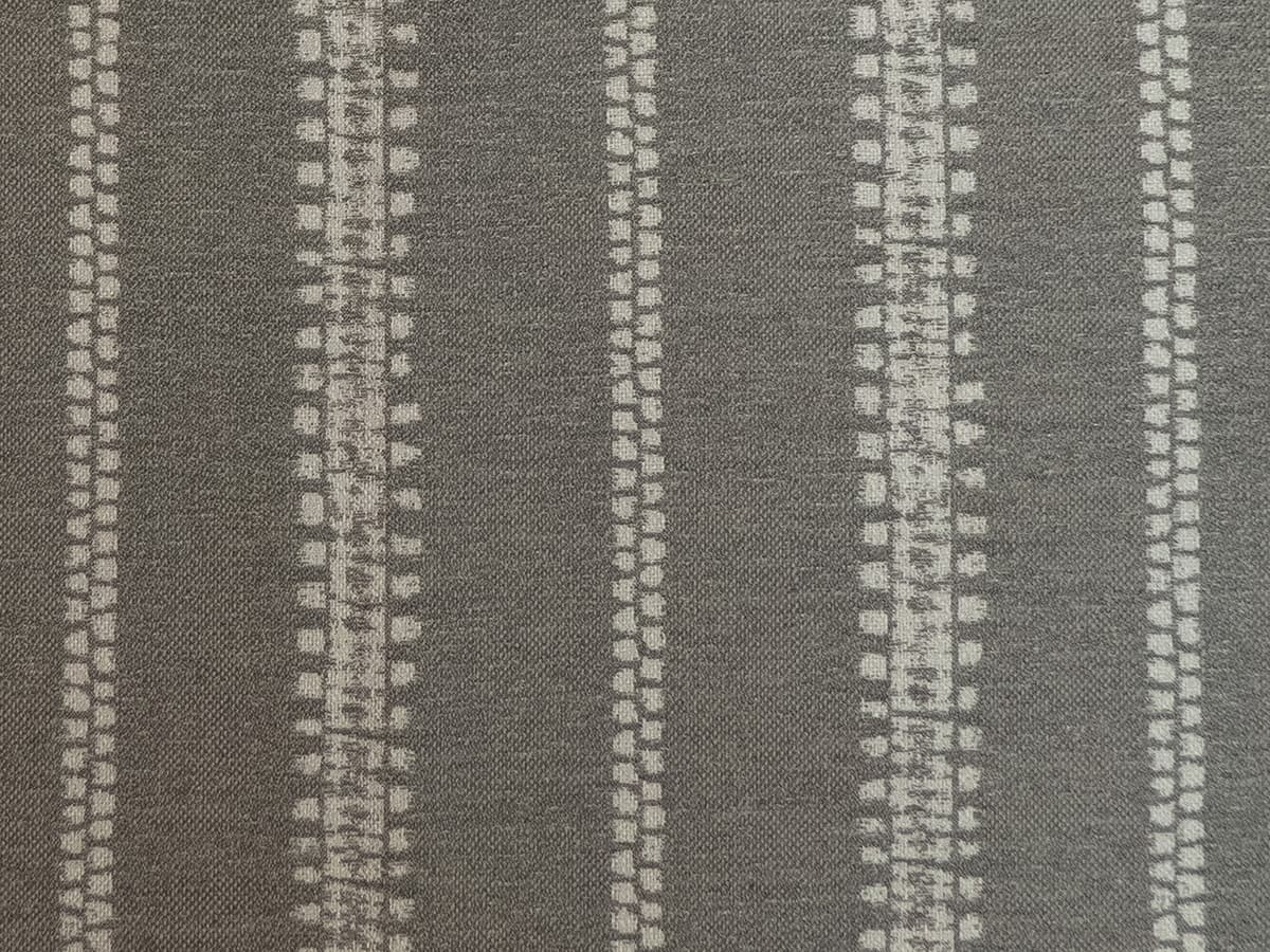 Detail of fabric in an irregular stripe print in gray on a slate field.