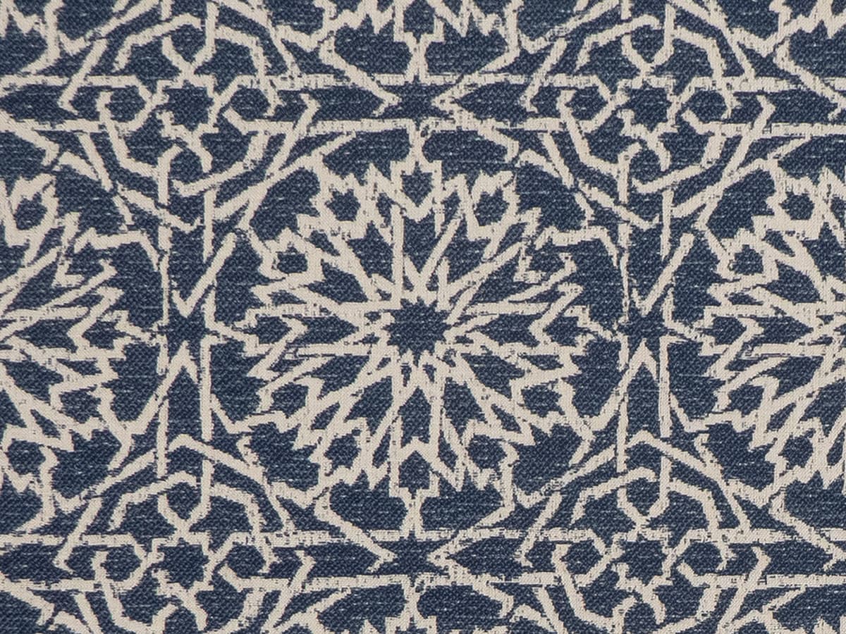 Detail of fabric in a small-scale lattice print in light brown on a navy field.