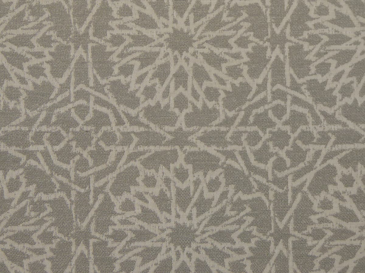 Detail of fabric in a small-scale lattice print in light gray on a gray field.