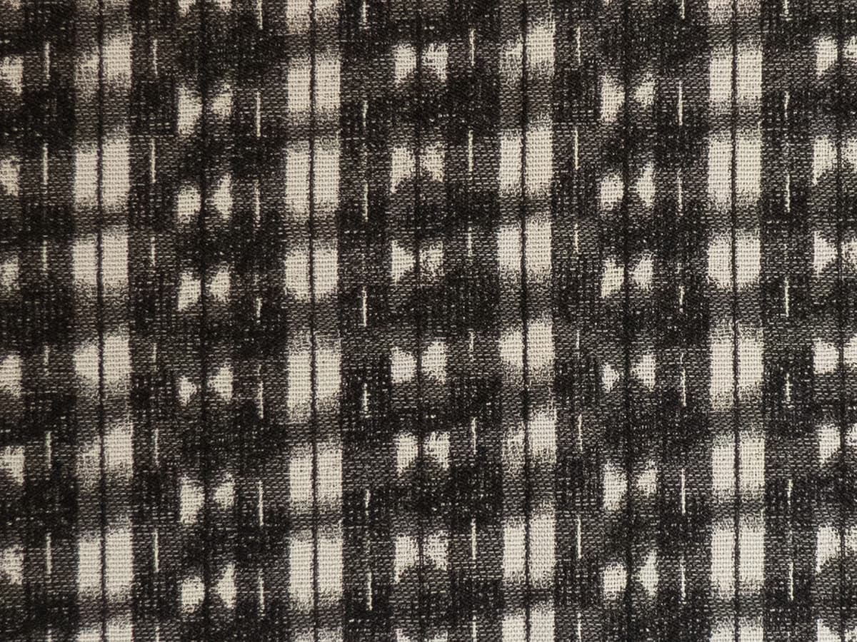 Detail of fabric in a textural shibori print in shades of charcoal on a greige field.