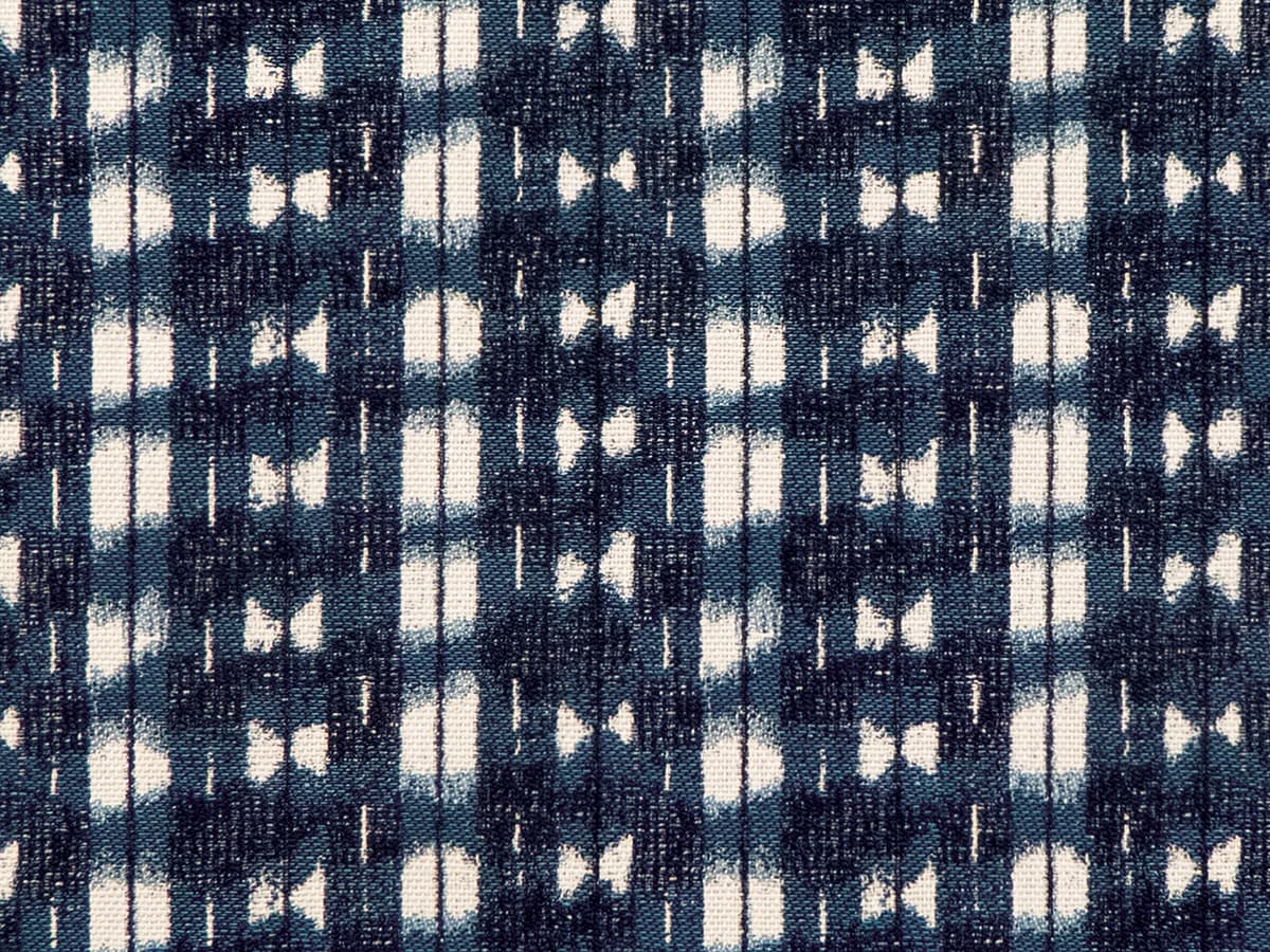 Detail of fabric in a textural shibori print in shades of navy on a greige field.