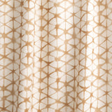 Draped fabric yardage in a painterly lattice print in brown on a cream field.