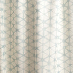 Draped fabric yardage in a painterly lattice print in light blue on a cream field.