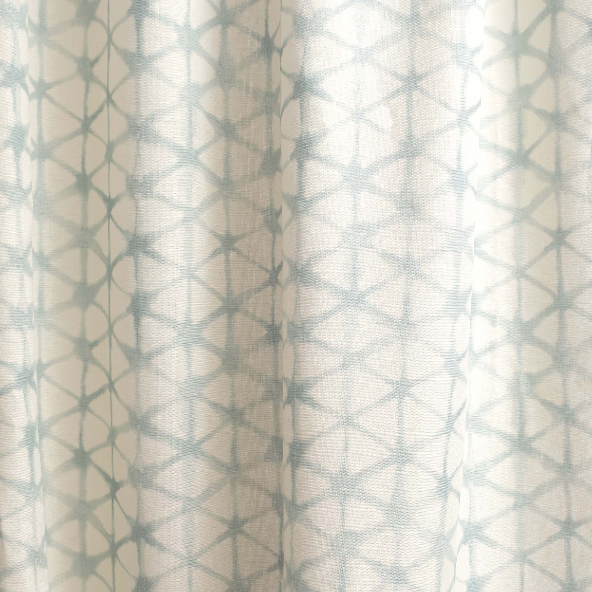 Draped fabric yardage in a painterly lattice print in light blue on a cream field.