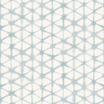 Detail of fabric in a painterly lattice print in light blue on a cream field.