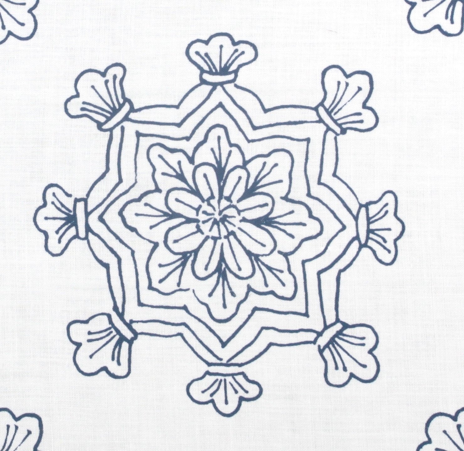 Detail of fabric in a floral medallion print in navy on a white field.