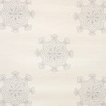 Detail of fabric in a floral medallion print in gray on a cream field.