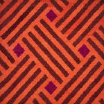 A woven rug with diagonal stipes in orange and brown and diamonds of purple.