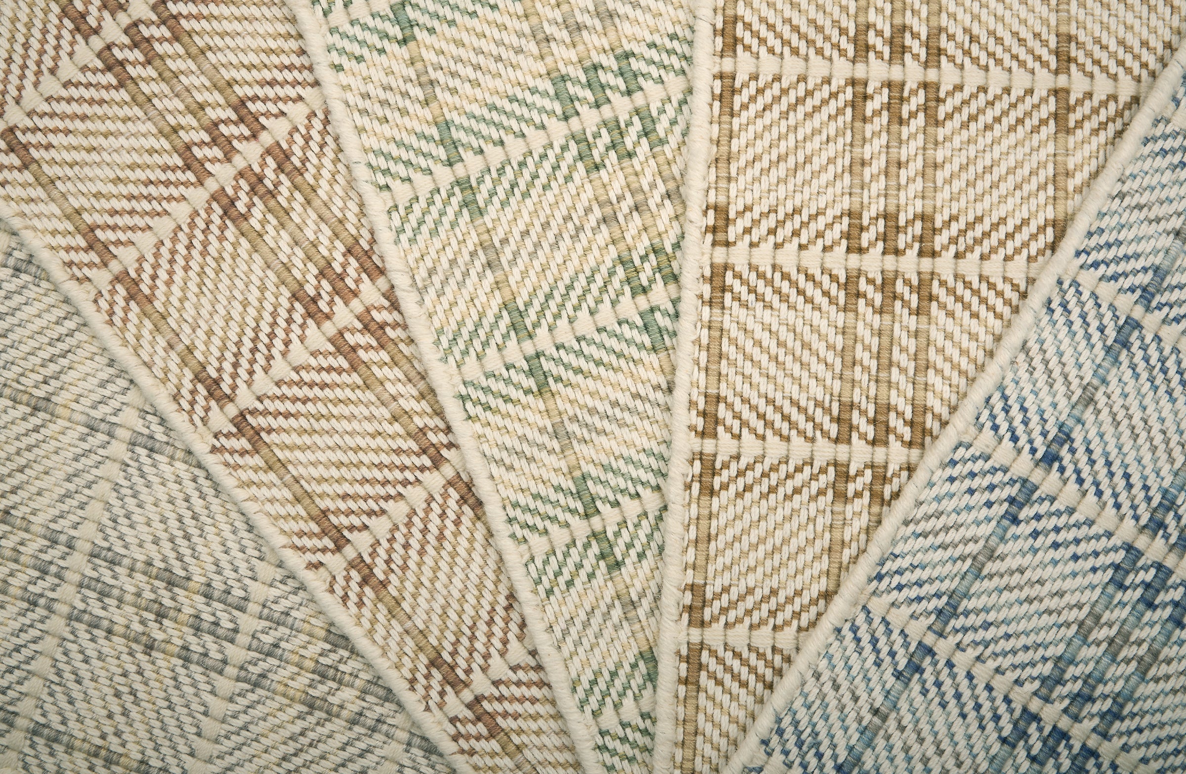 Close-up of f broadloom samples with plaid pattern in beige, brown, and blue.