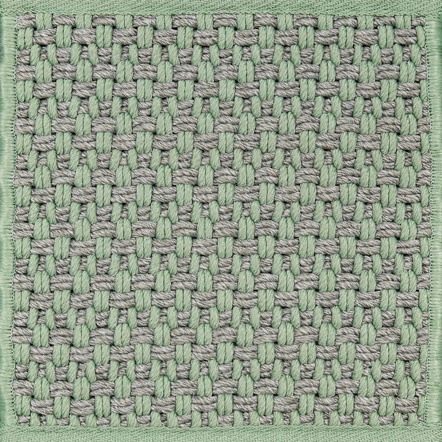 Textured woven outdoor carpet a basketweave design in grey and green.