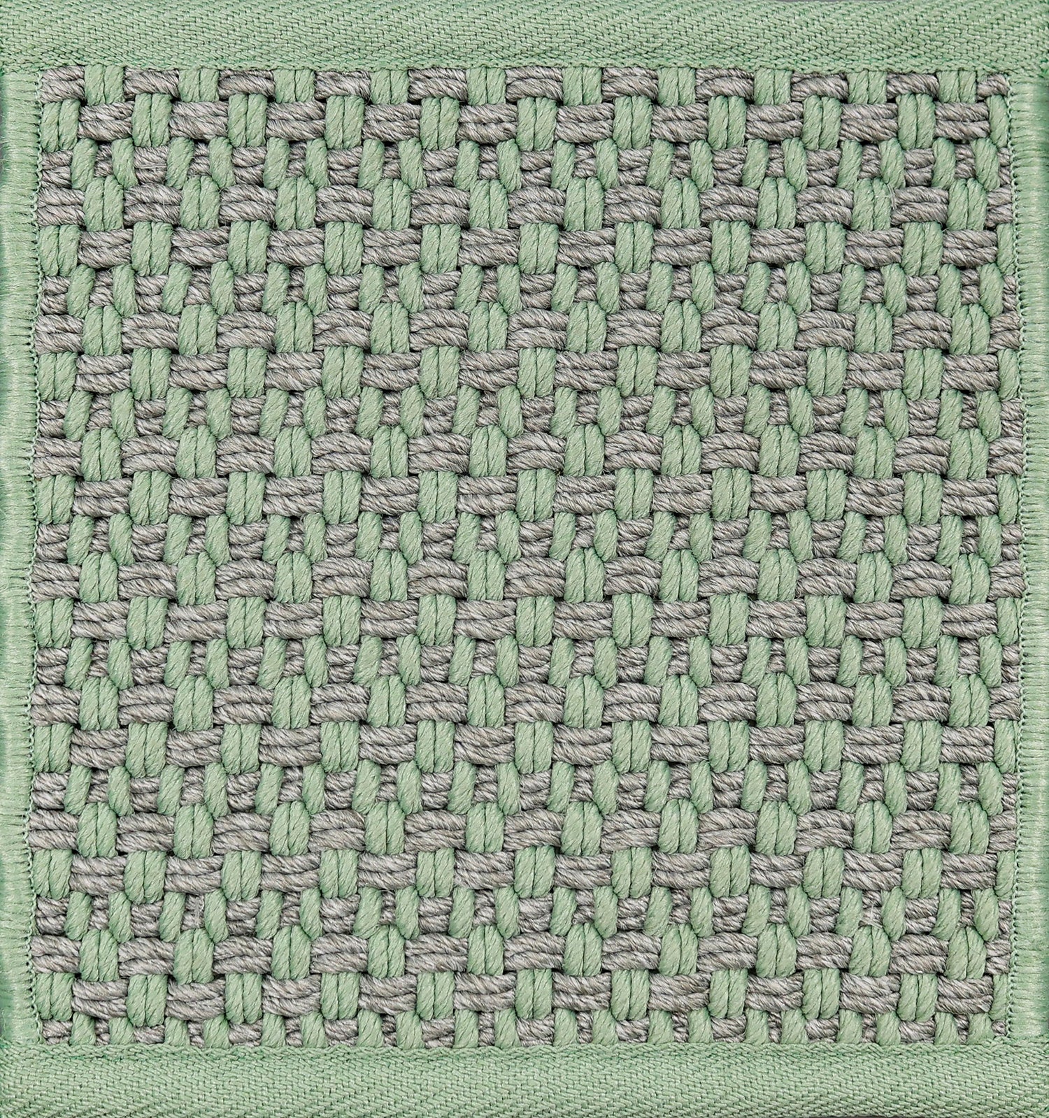 Textured woven outdoor carpet a basketweave design in grey and green.