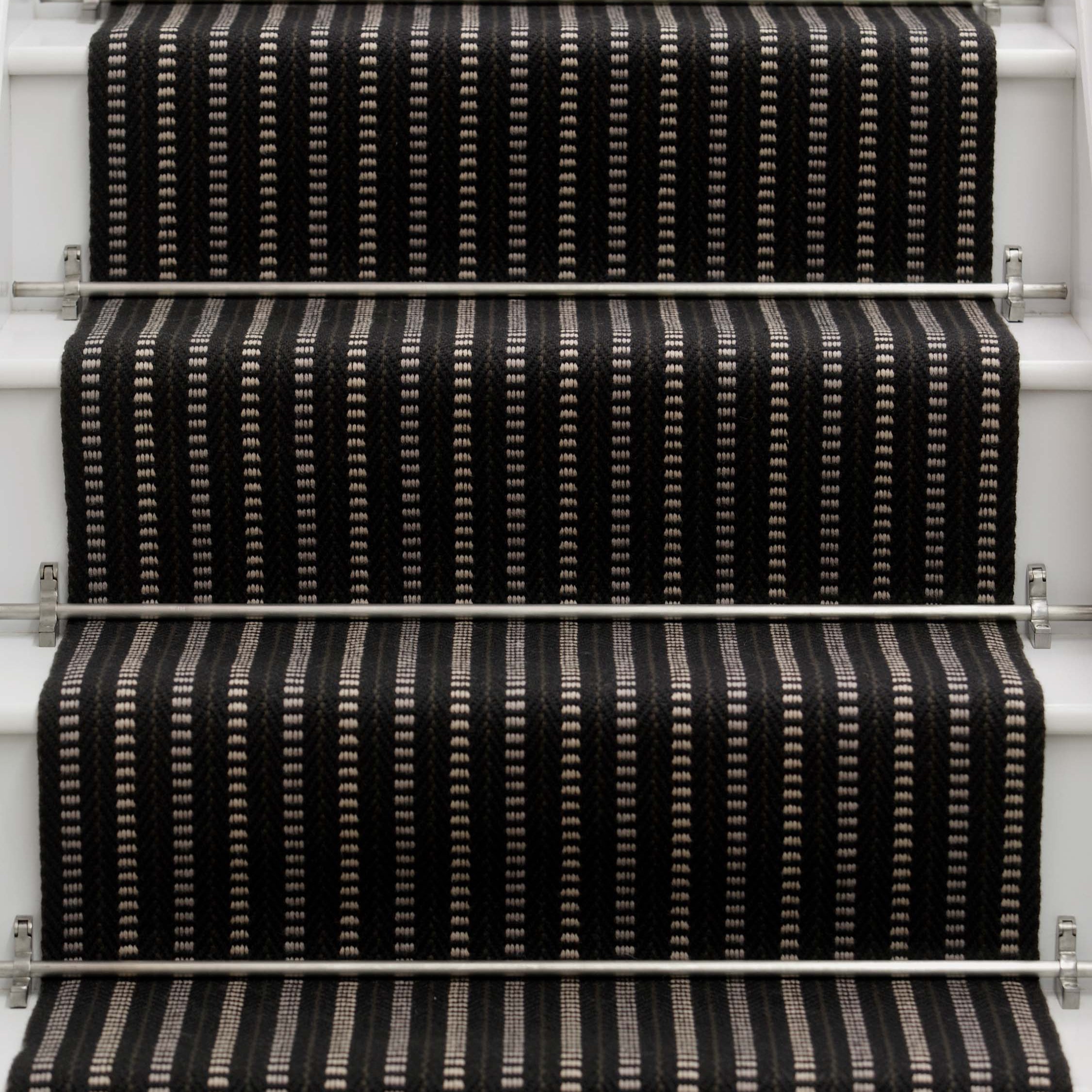 Striped flatweave runner in black and white on white staircase