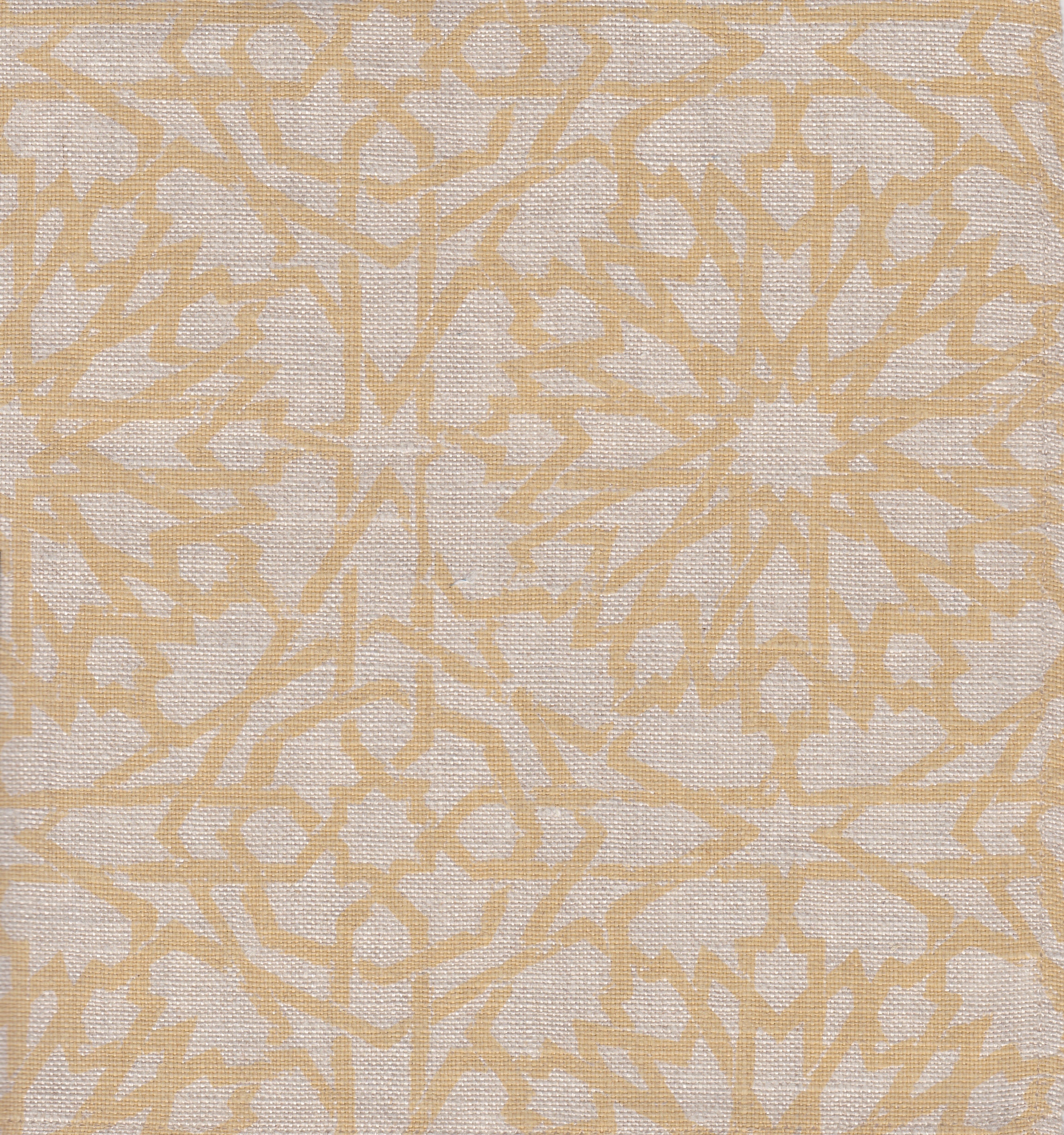 Detail of fabric in a small-scale lattice print in yellow on a cream field.