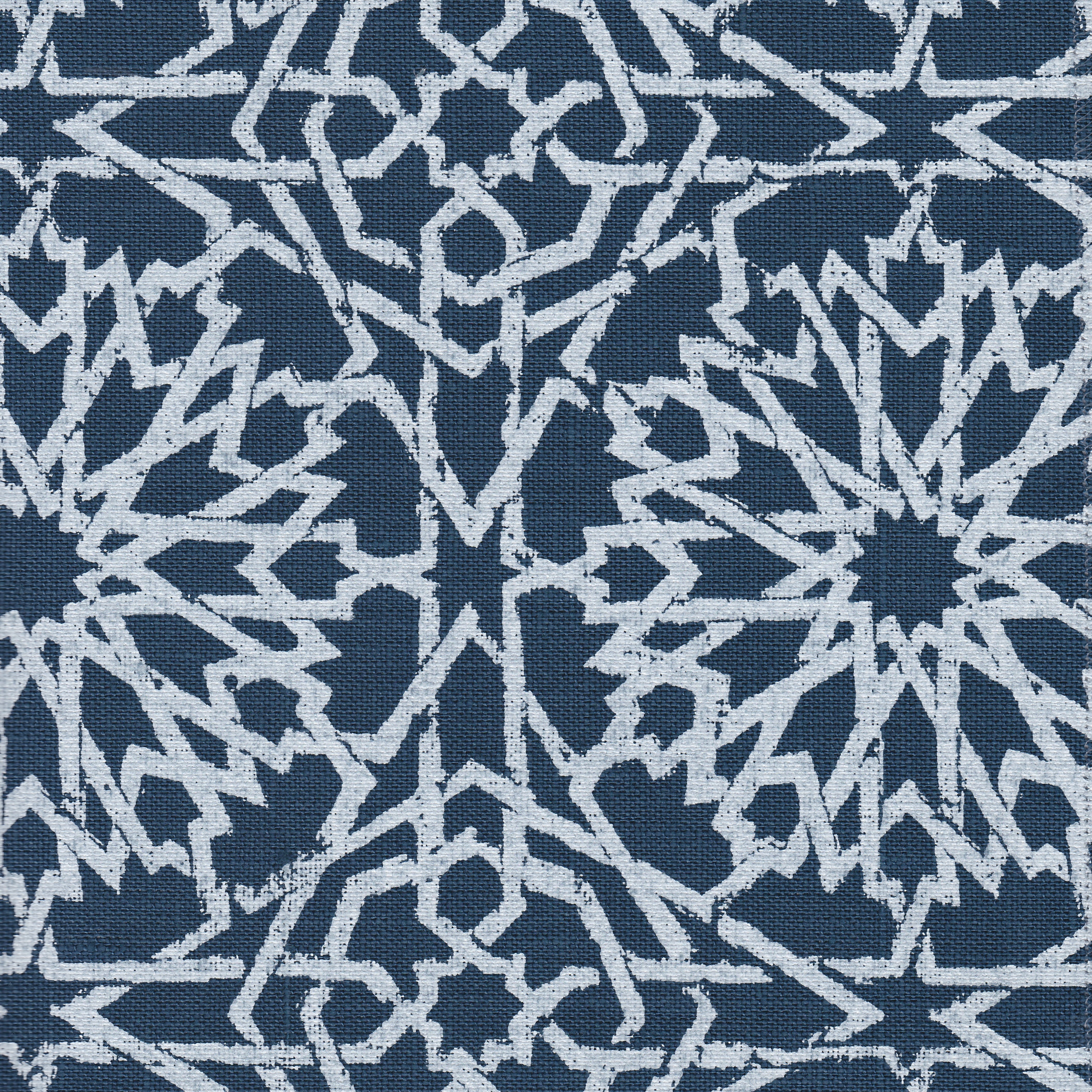 Detail of fabric in a small-scale lattice print in light blue on a navy field.