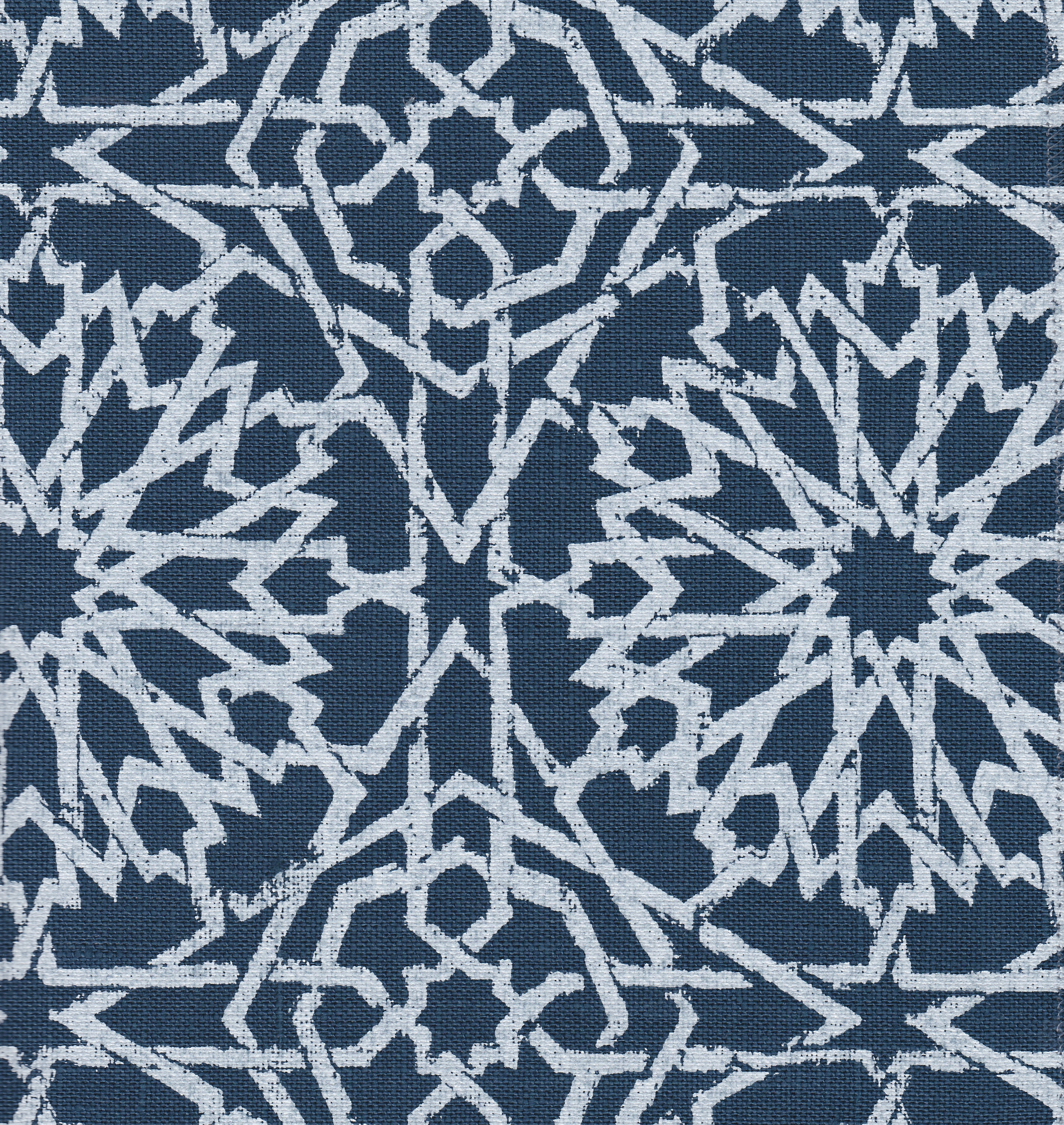 Detail of fabric in a small-scale lattice print in light blue on a navy field.