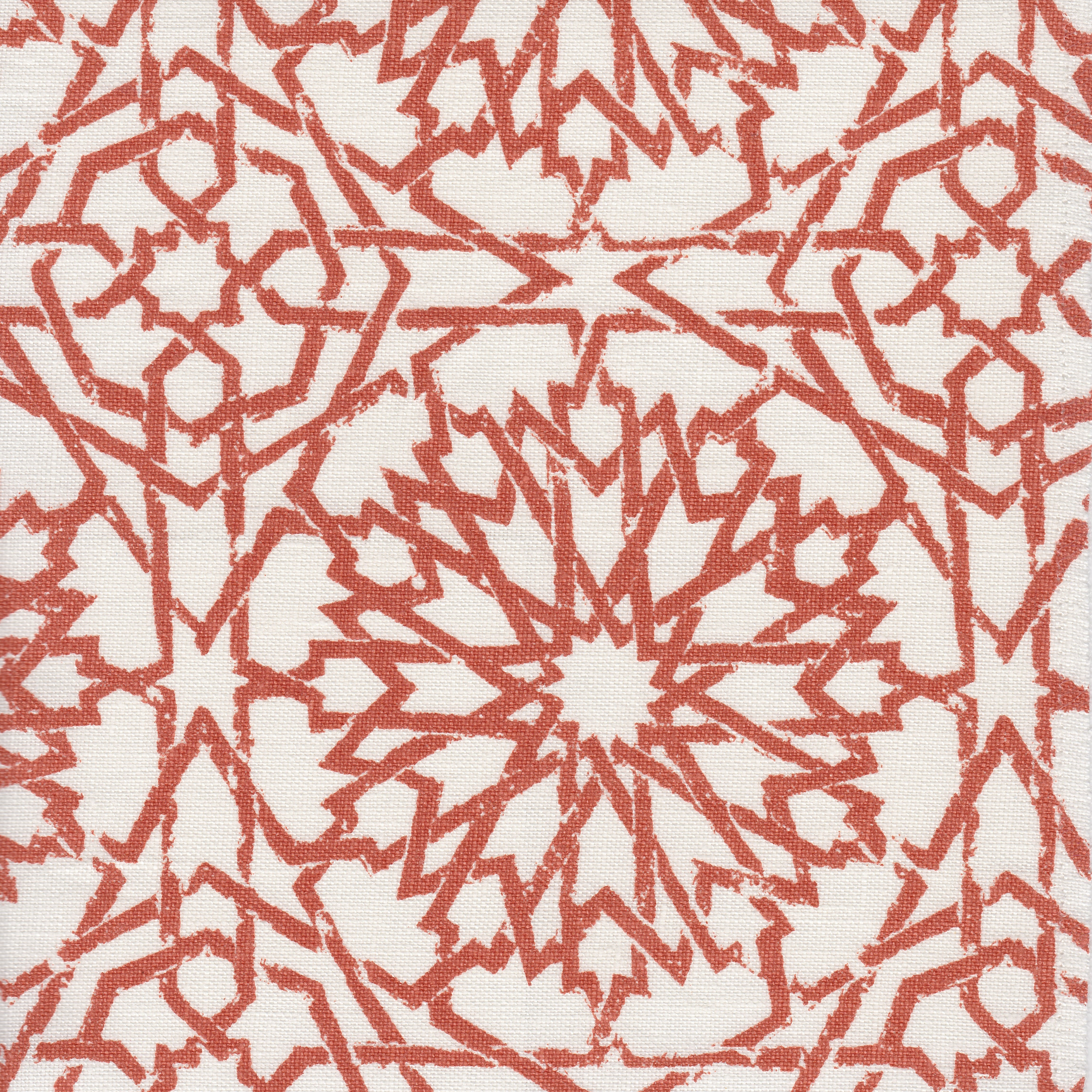 Detail of fabric in a small-scale lattice print in rust on a white field.