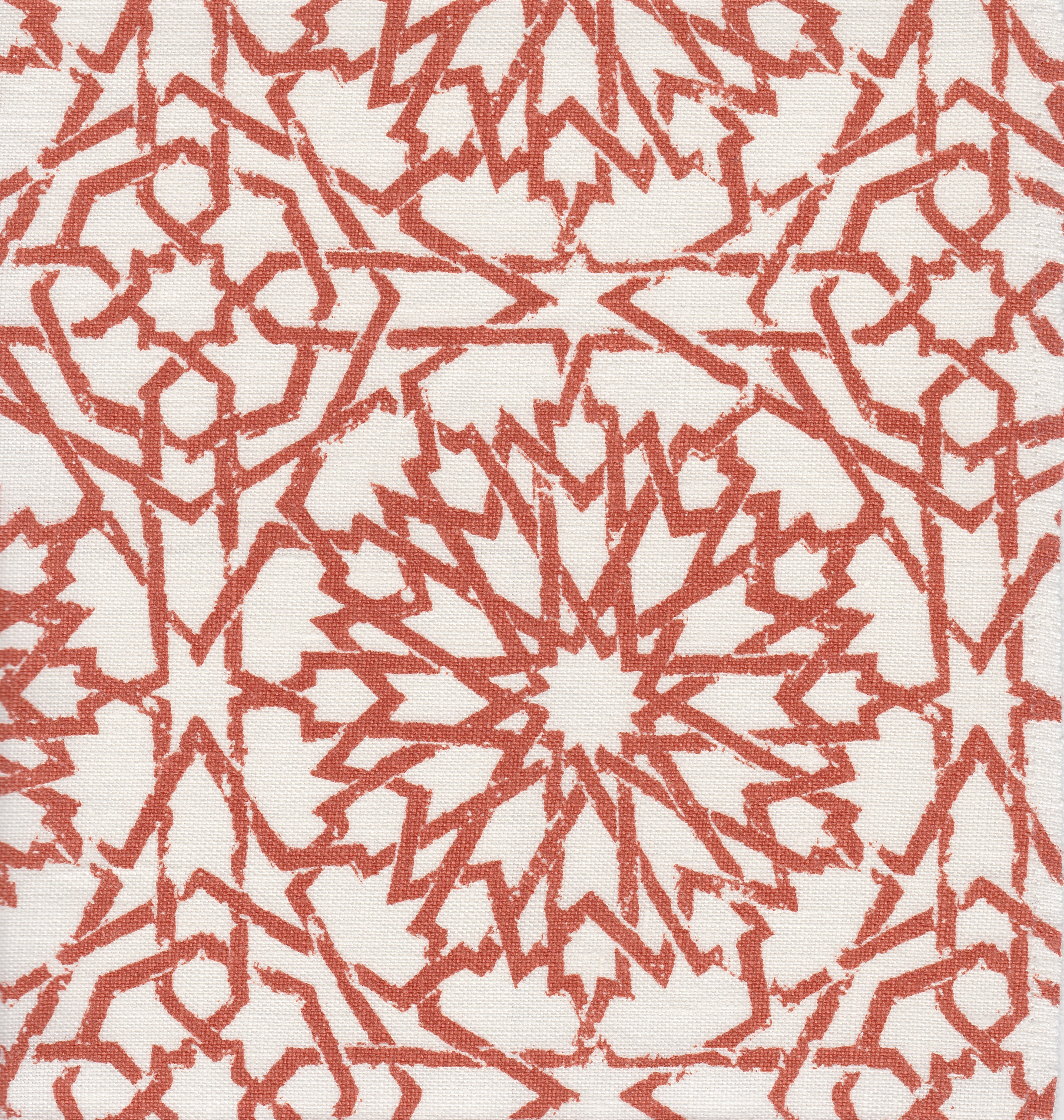 Detail of fabric in a small-scale lattice print in rust on a white field.