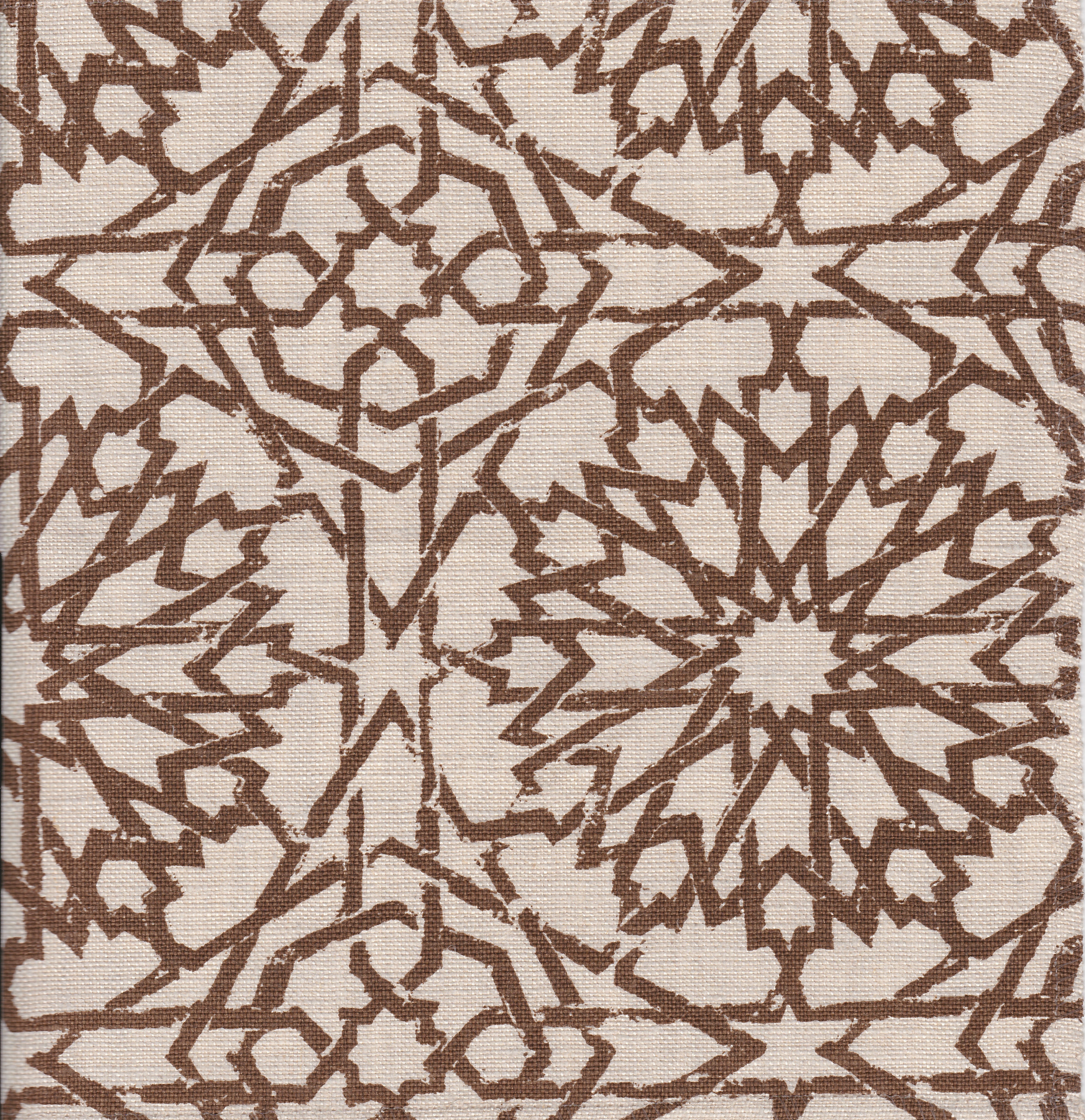 Detail of fabric in a small-scale lattice print in brown on a cream field.