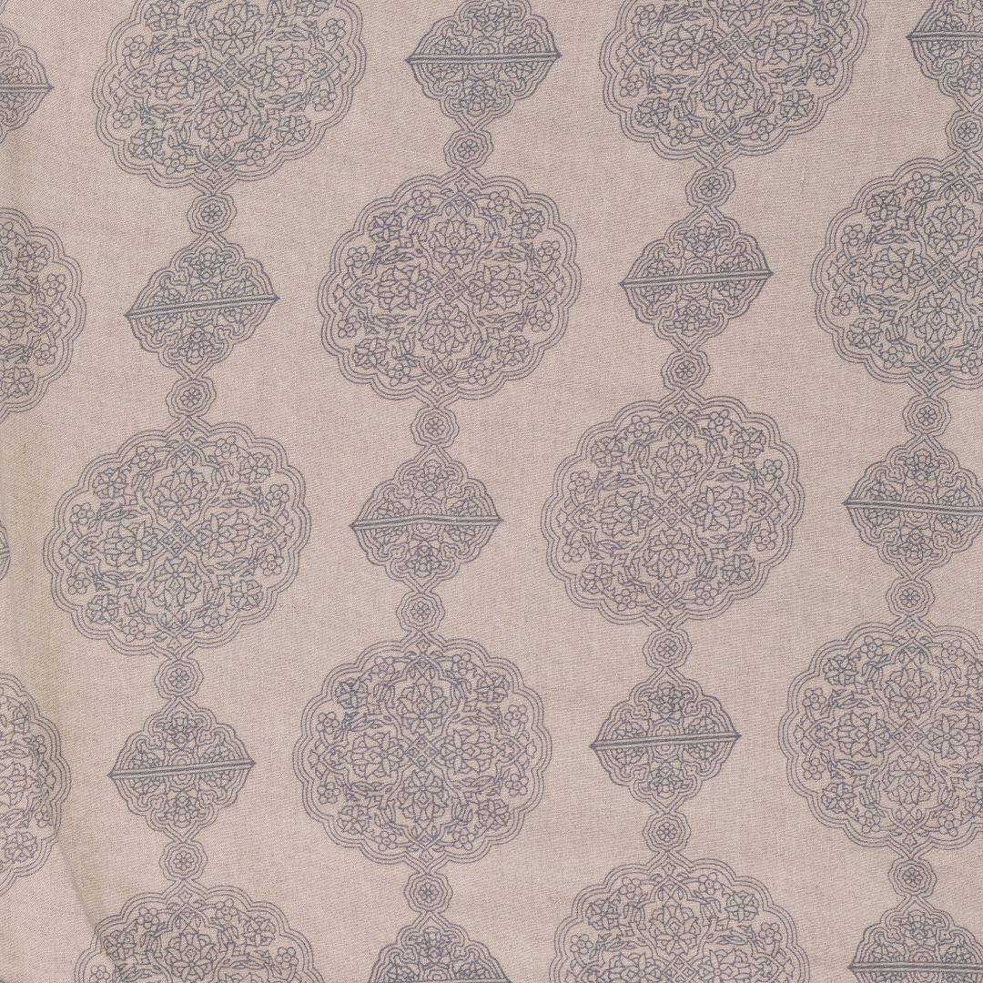 Detail of fabric in a paisley medallion print in gray on a tan field.