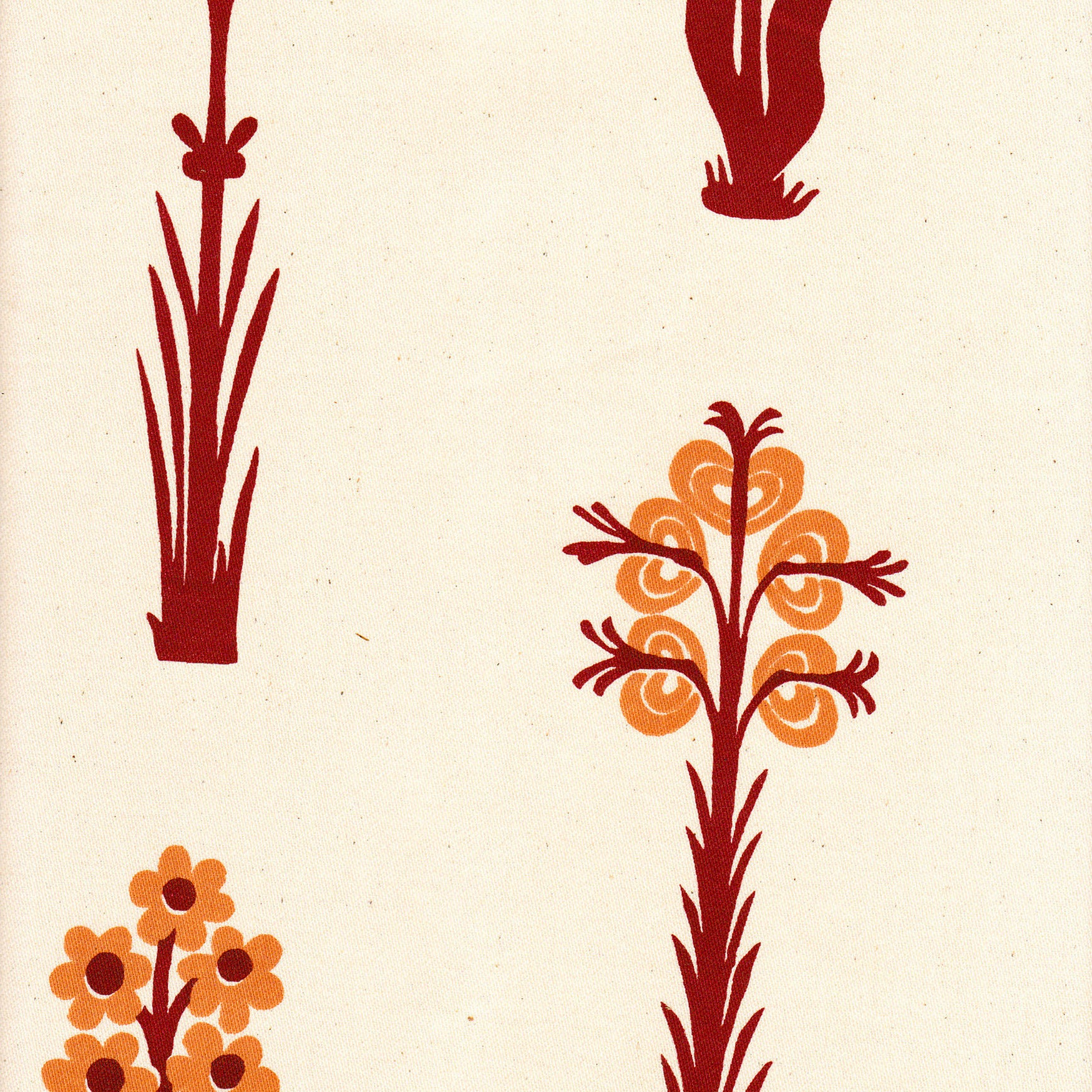 Detail of fabric in a playful floral print in red and orange on a cream field.