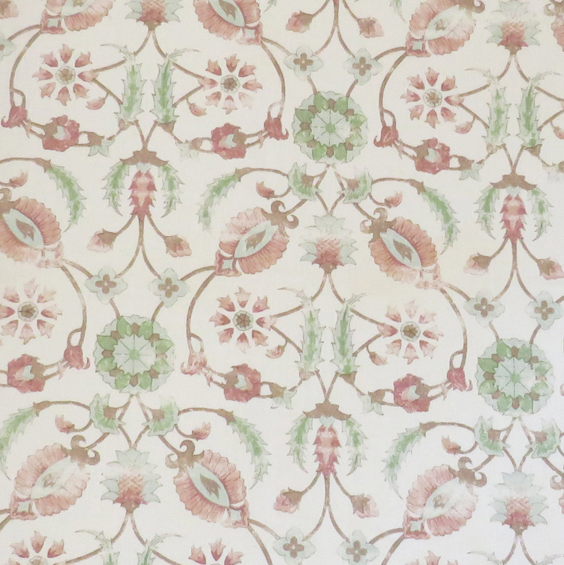 Detail of fabric in a floral paisley print in shades of rust and green on a cream field.