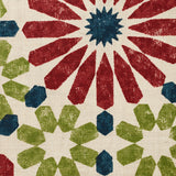 Detail of fabric in a geometric lattice print in shades of red, blue and green on a cream field.