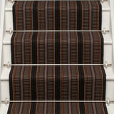 Striped flatweave runner in orange brown and black on white staircase