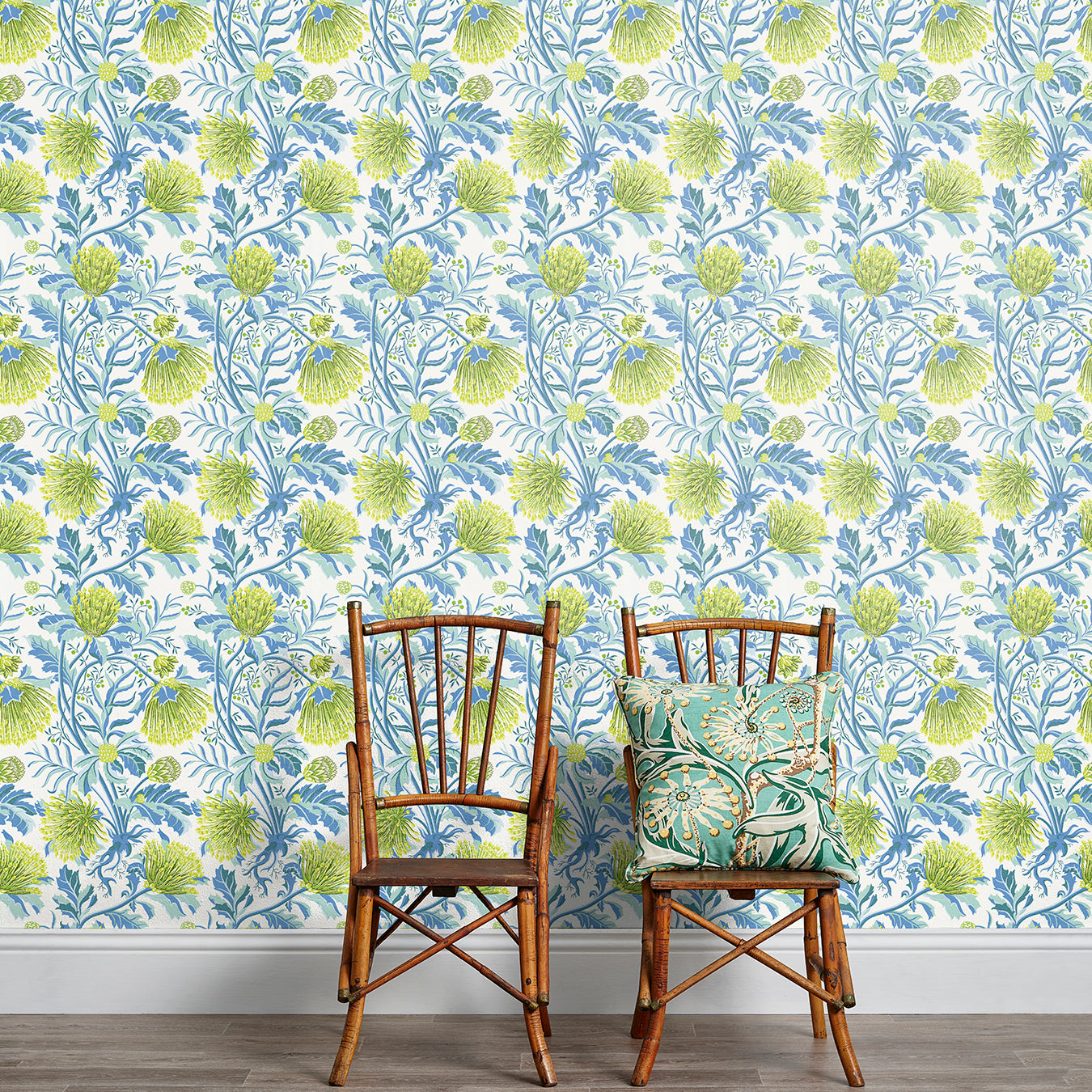 An armchair stands in front of a wall papered in a painterly floral print in white, blue and navy.