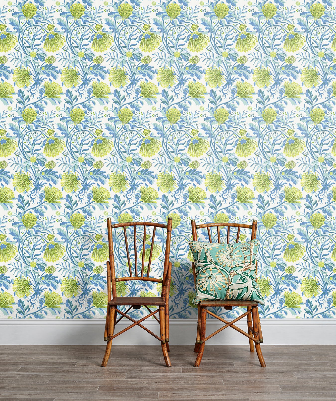 An armchair stands in front of a wall papered in a painterly floral print in white, blue and navy.