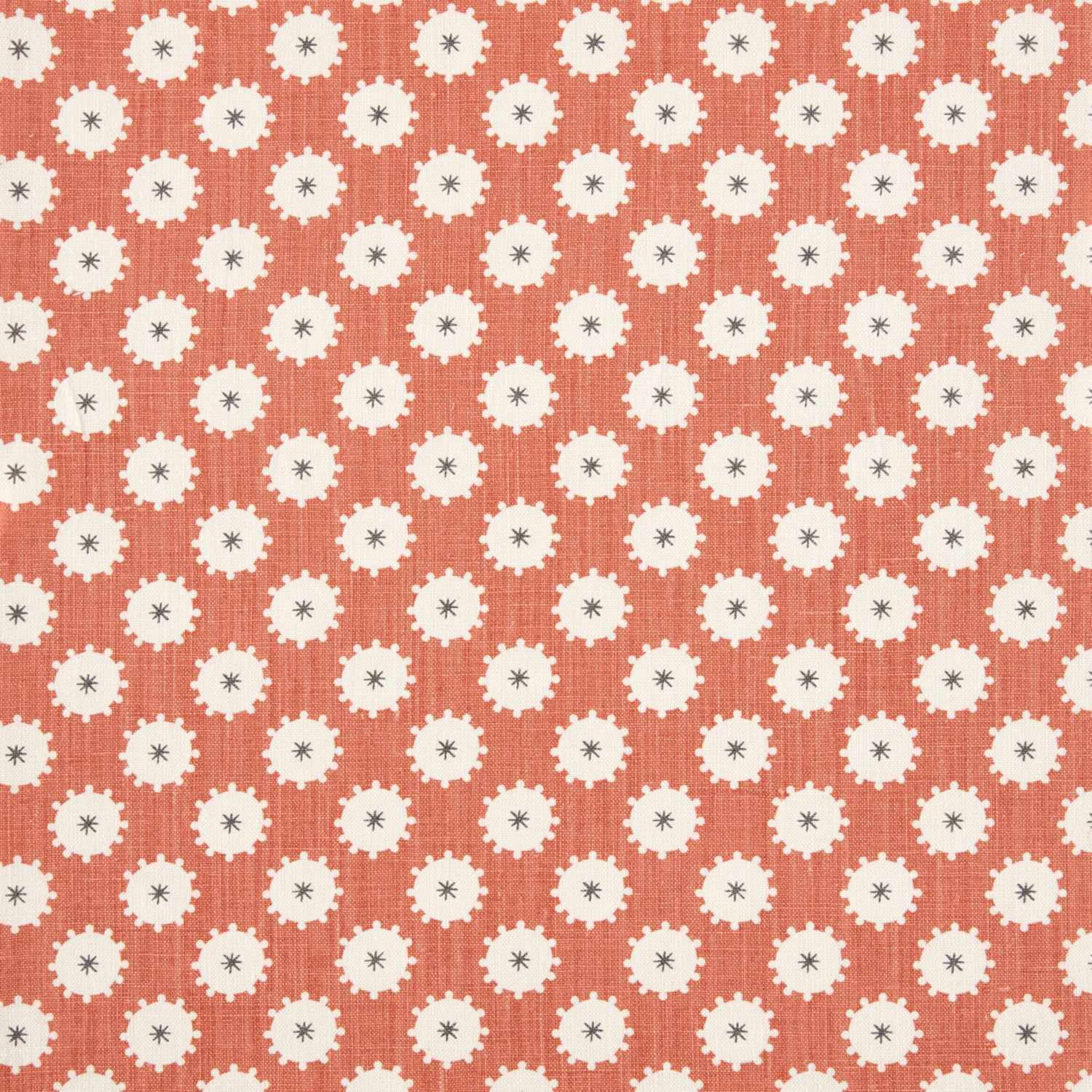 Detail of fabric in a repeating blossom print in white on a burnt orange field.