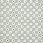 Detail of fabric in a repeating blossom print in white on a gray field.