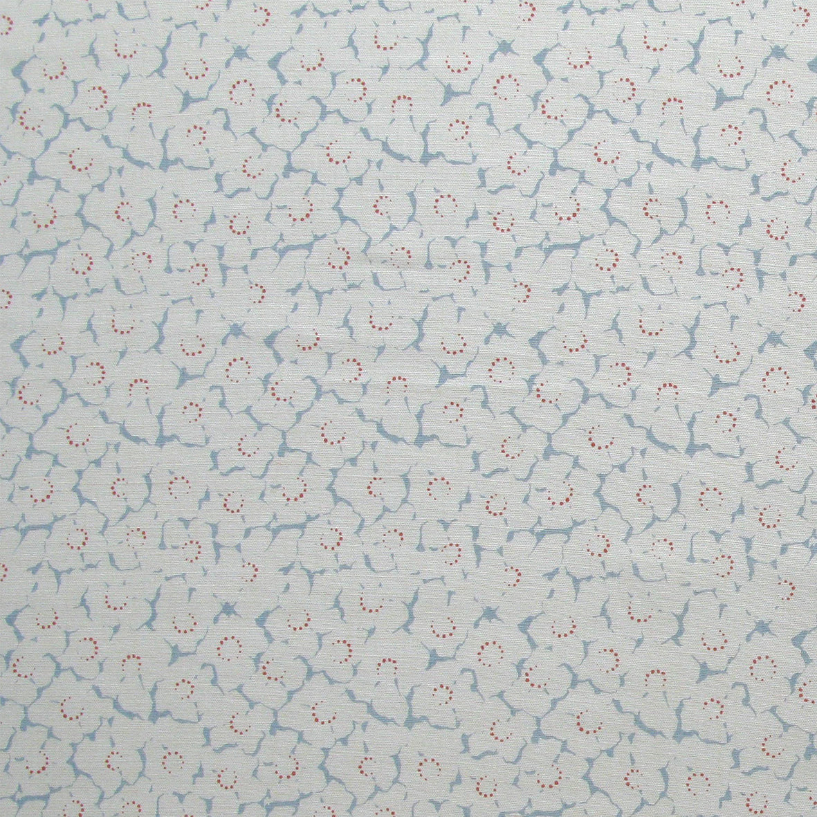 Fabric in a minimal floral print in red and blue on a light gray field.