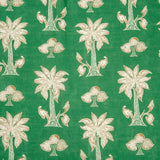 Detail of fabric in a playful palm tree print in white and red on a green field.