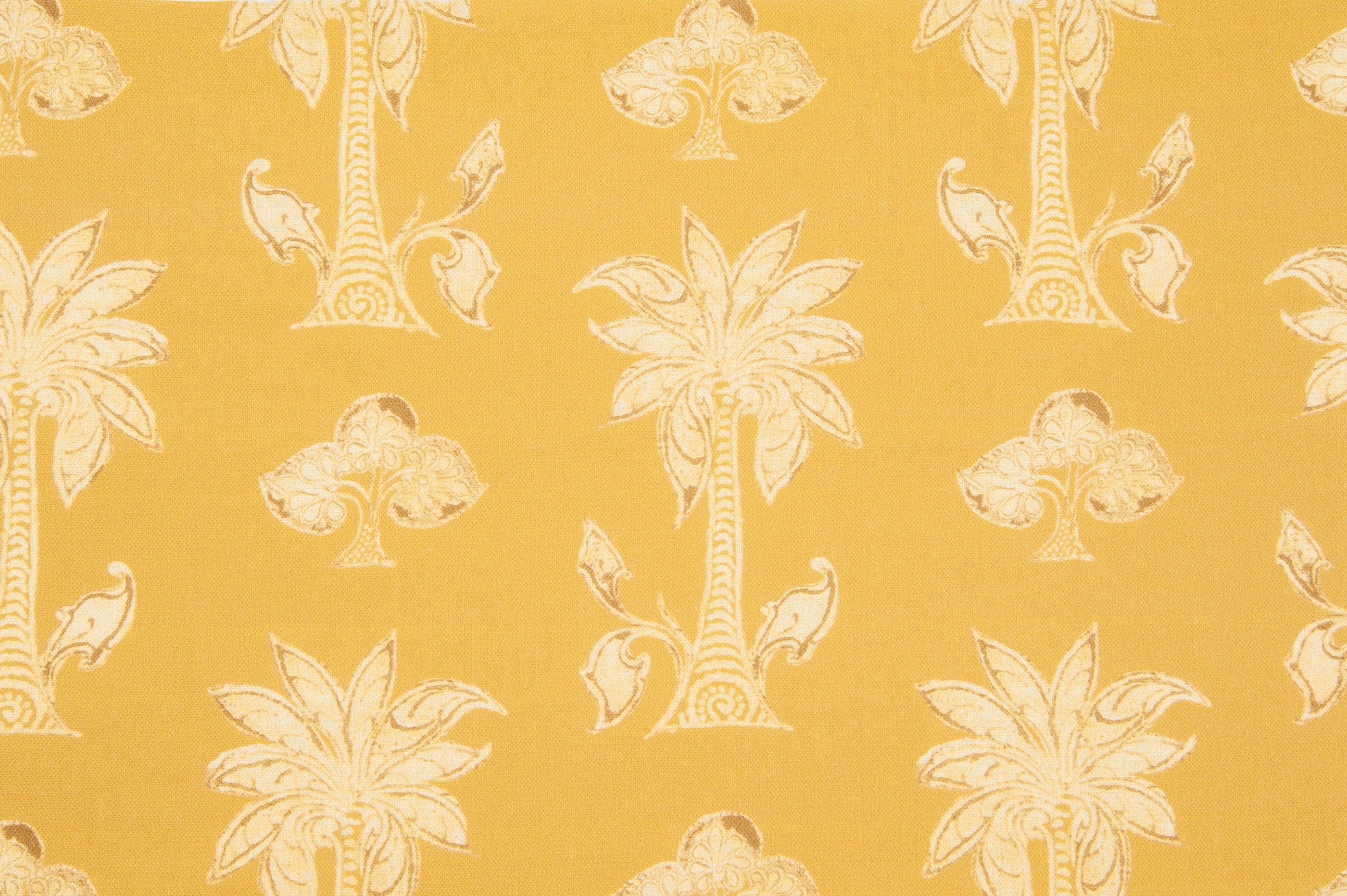 Detail of fabric in a playful palm tree print in tan and white on a yellow field.