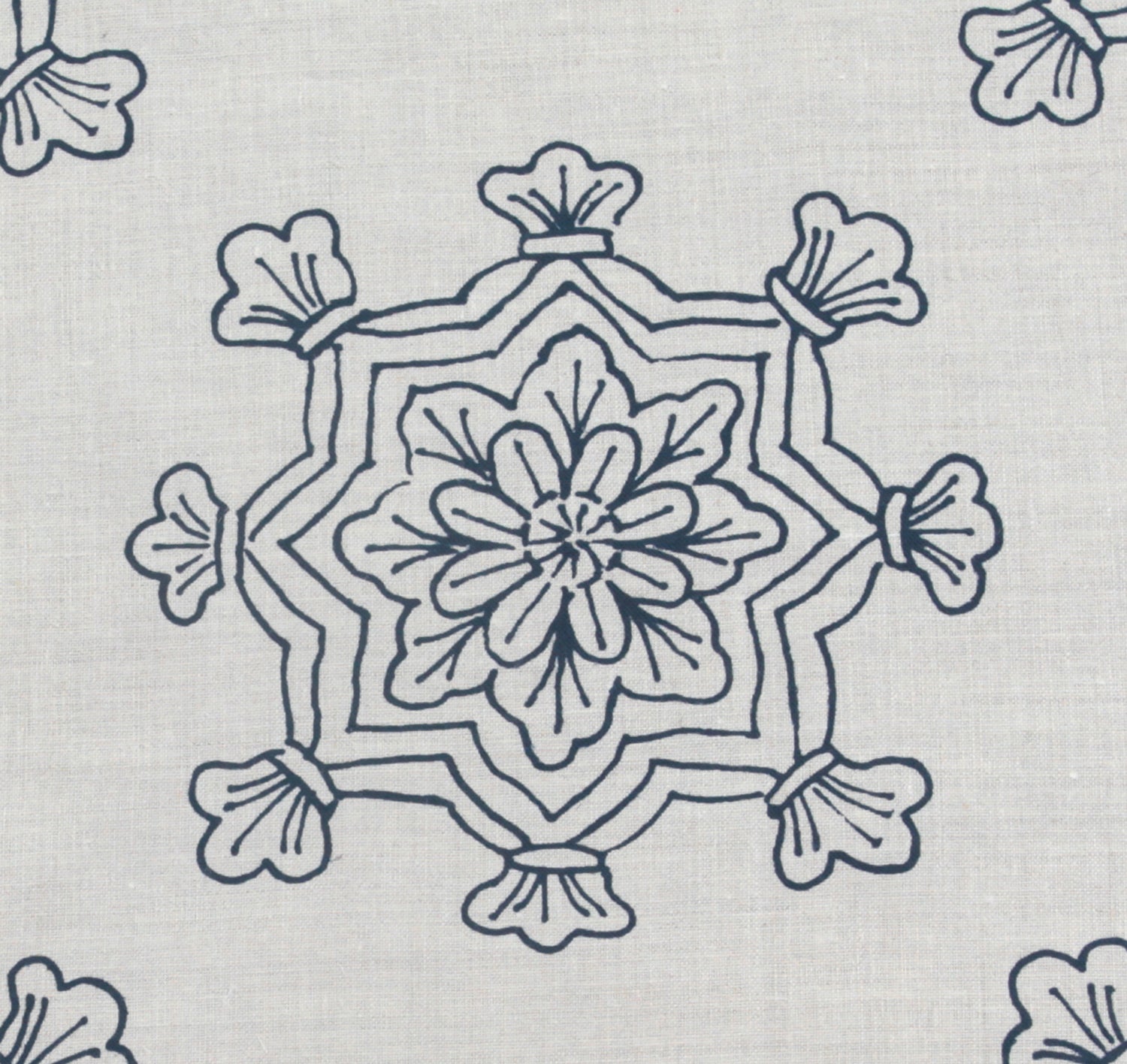 Detail of fabric in a floral medallion print in navy on a cream field.