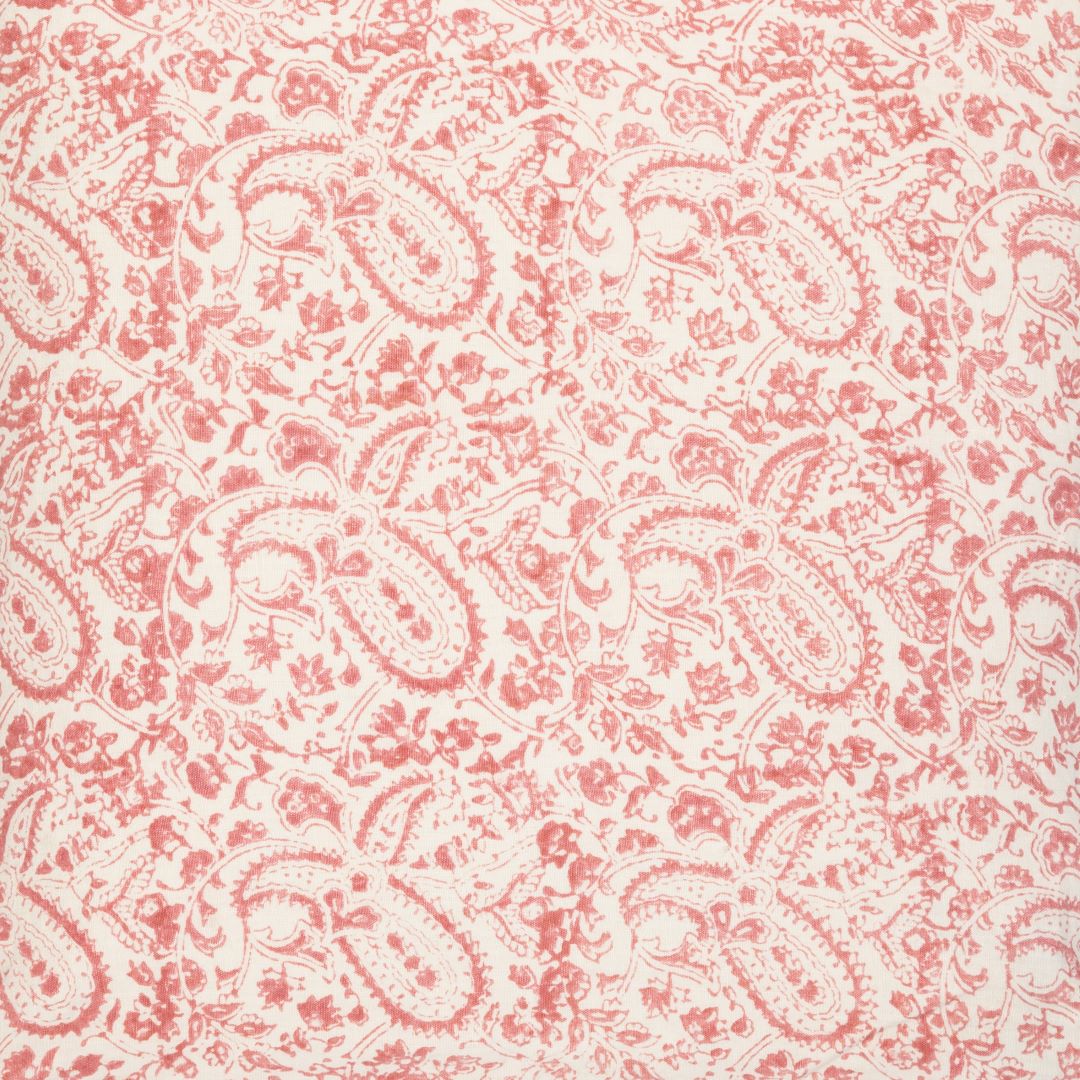 Detail of fabric in a paisley print in red on a cream field.
