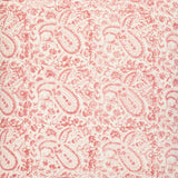 Detail of fabric in a paisley print in red on a cream field.