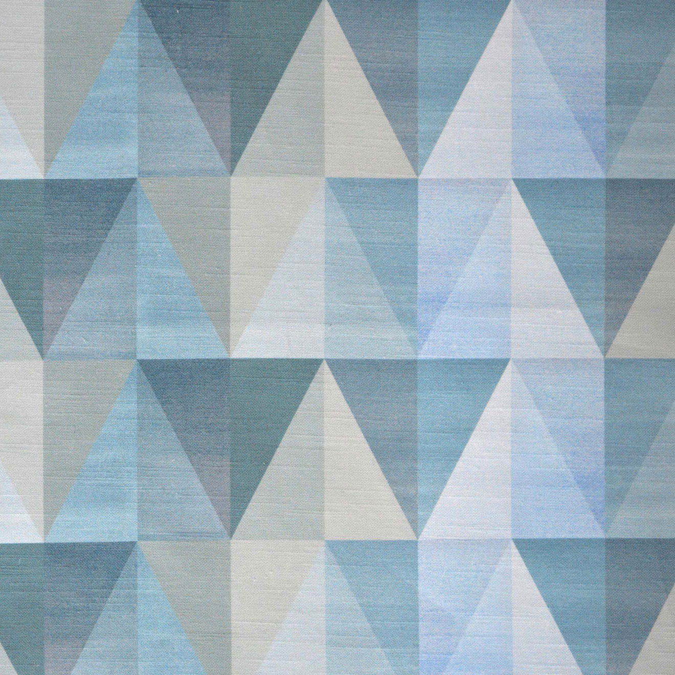 Detail of fabric in a linear triangle print in shades of tan, navy and blue.