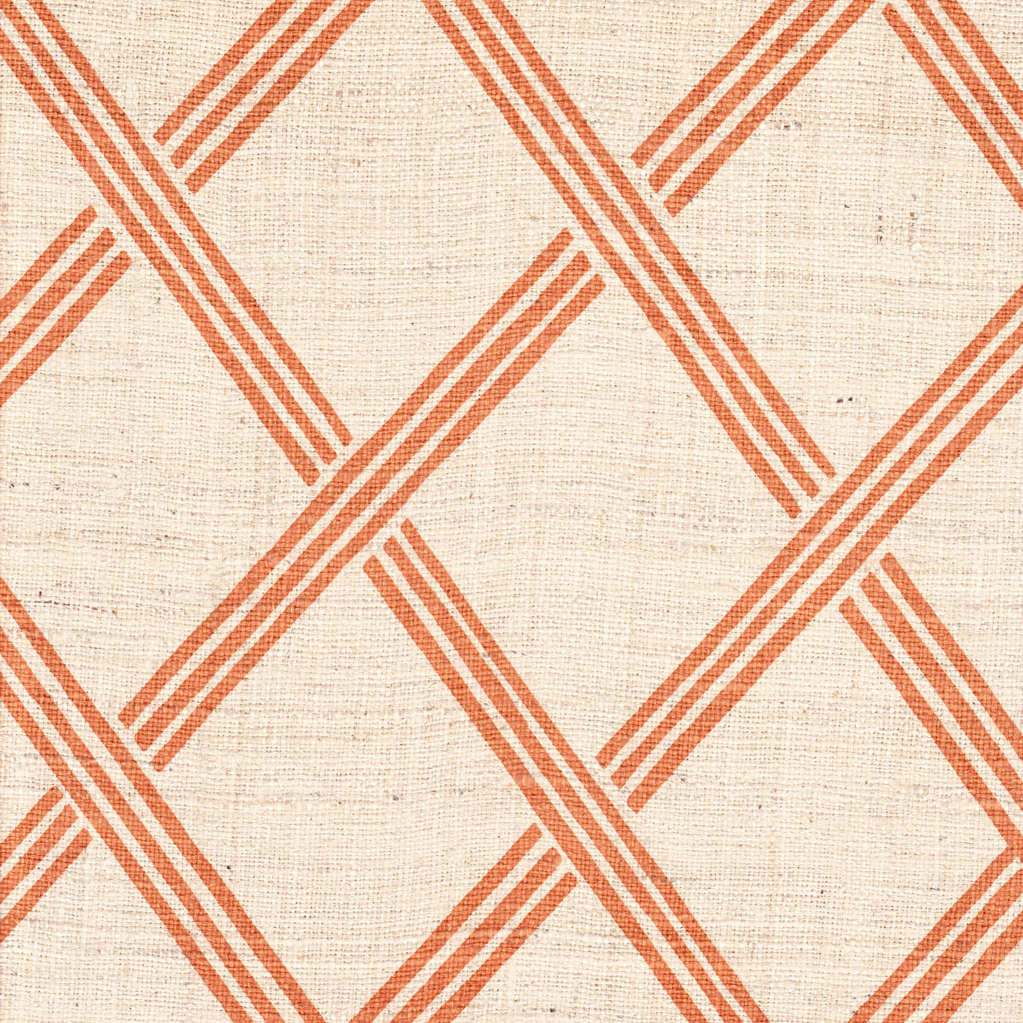 Detail of fabric in a diamond lattice print in orange on a cream field.