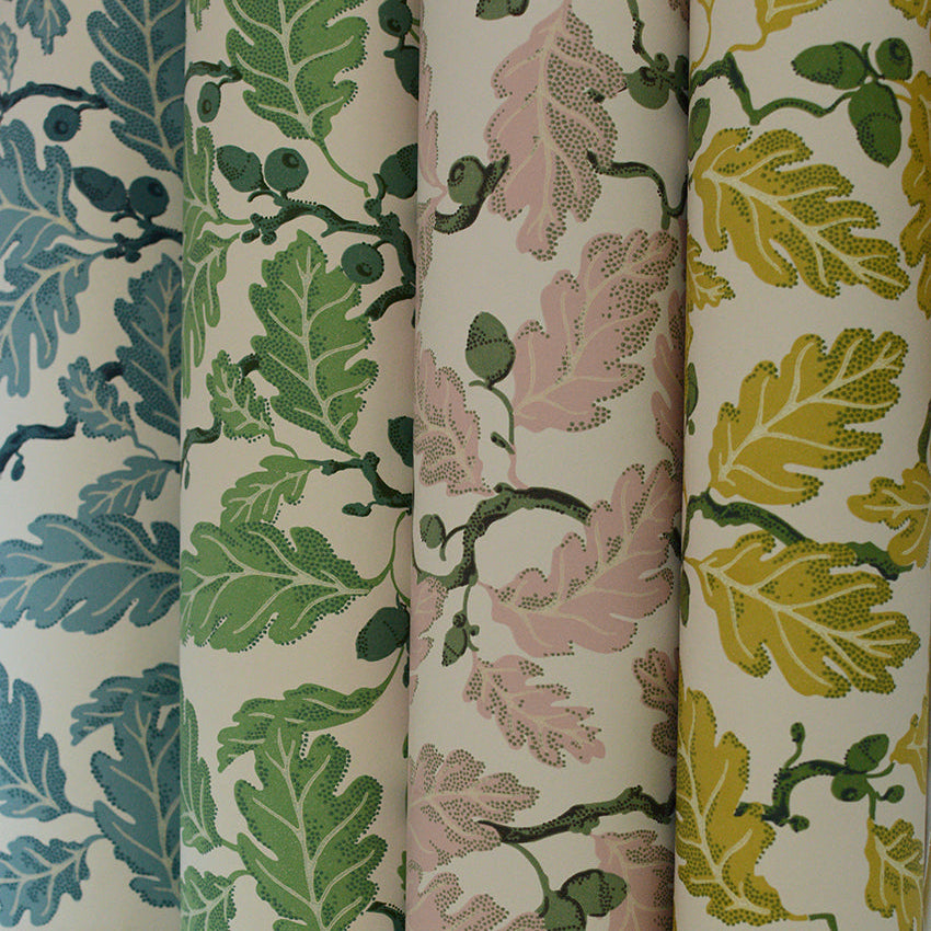 Four rolls of fabric with leaf patterns in green, pink, and yellow on a white background.