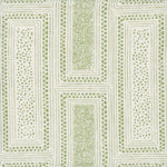 Detail of fabric in a complex interlocking geometric print in green on a cream field.