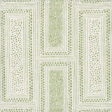 Detail of fabric in a complex interlocking geometric print in green on a cream field.