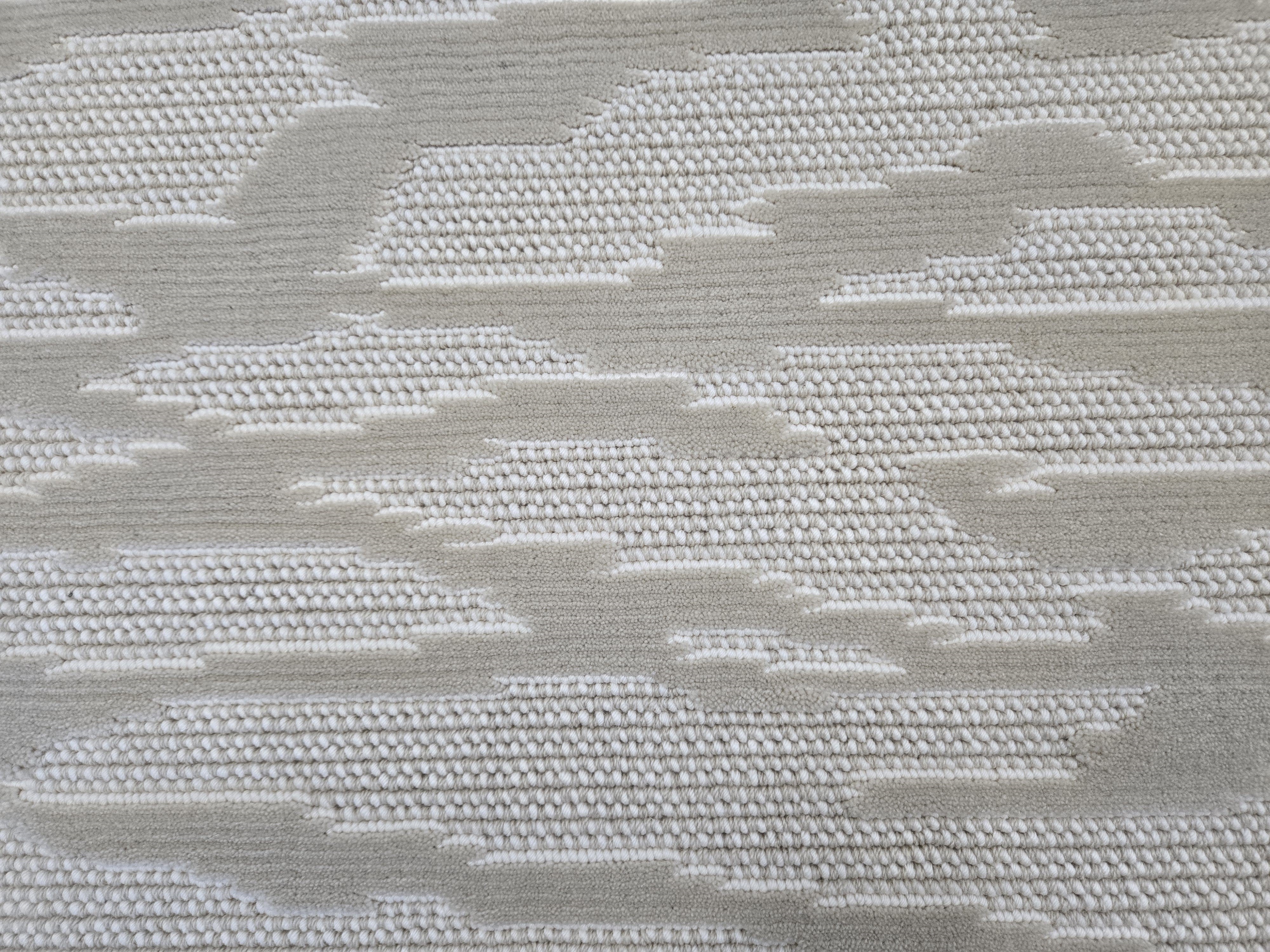 Broadloom carpet detail in an abstract cloud design in cream and taupe.